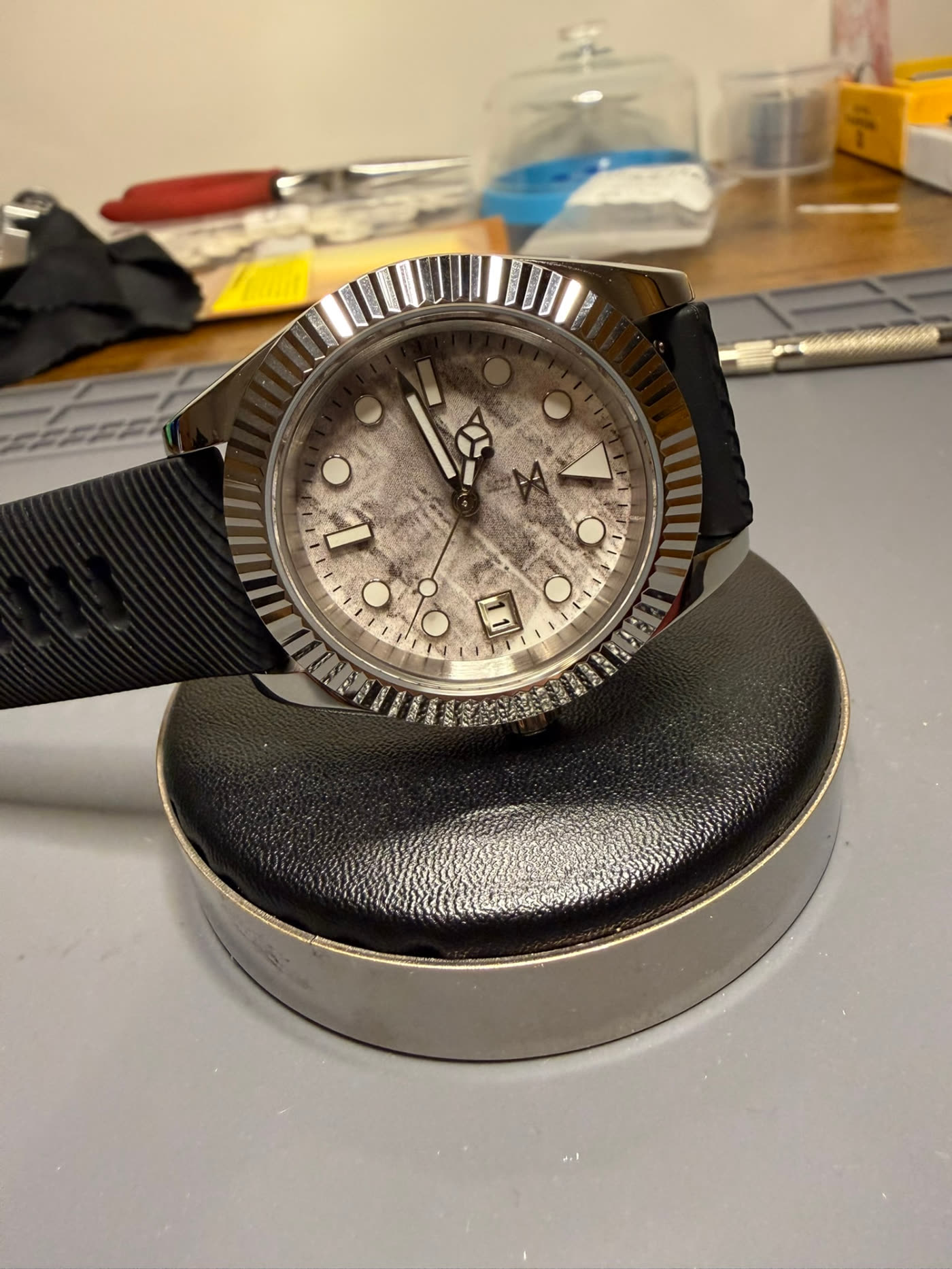 Textured stone dial with fluted bezel, raised three-quarter view