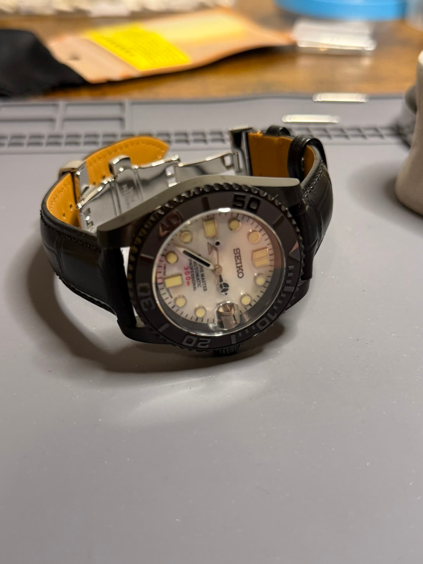 Mother-of-pearl dial in a black case, raised three-quarter view