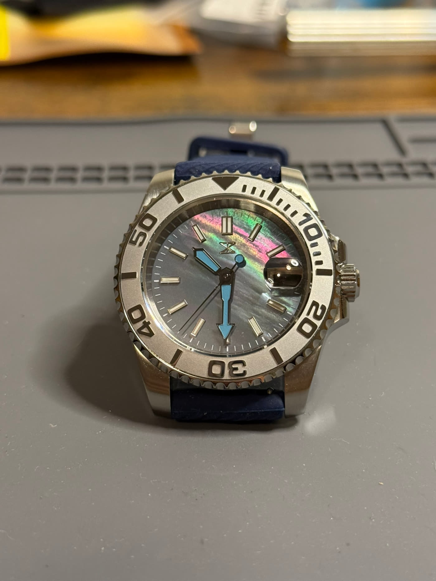 Polished bezel with iridescent dial, raised three-quarter view