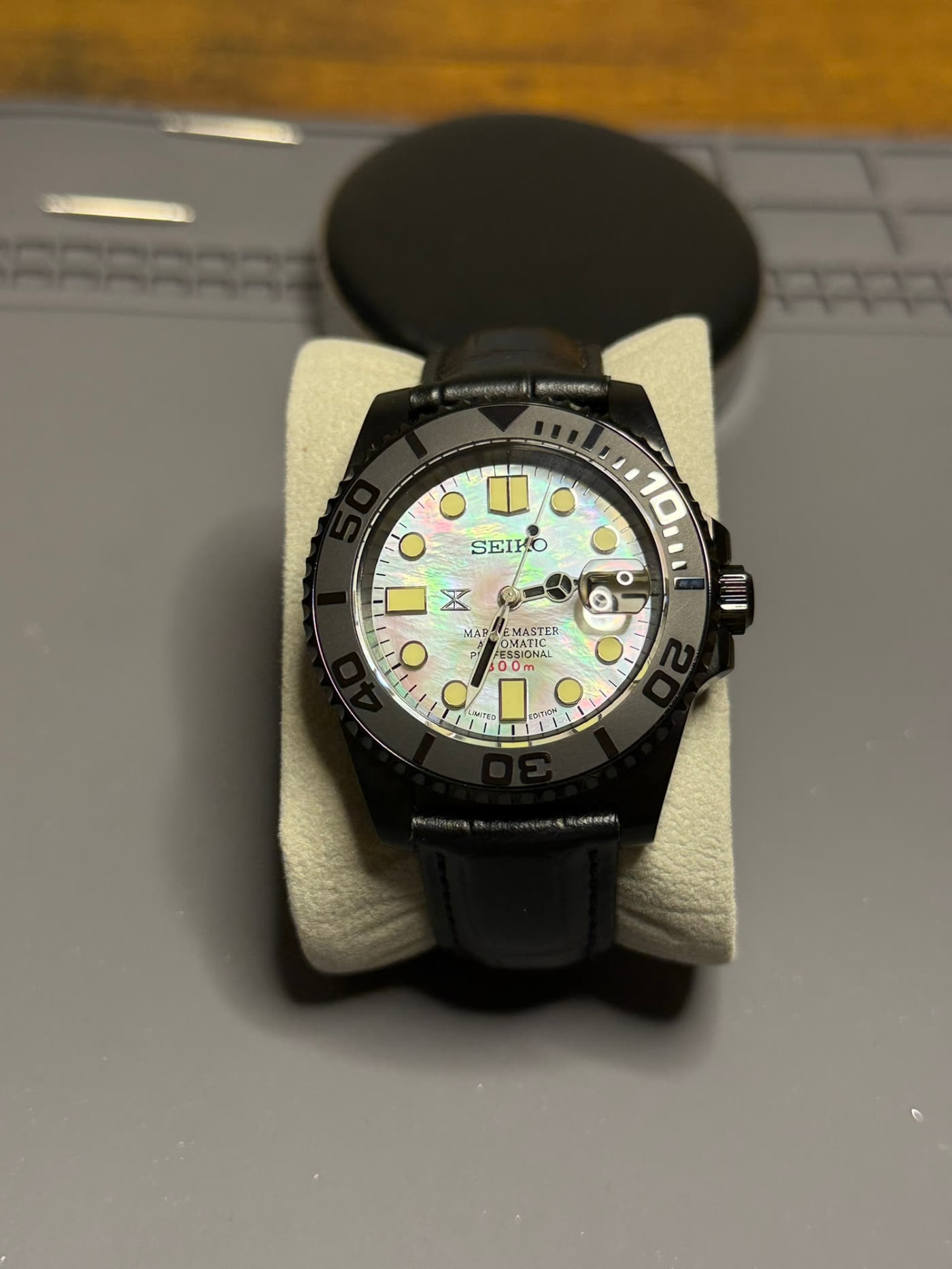 Mother-of-pearl dial resting on a casing cushion, dial face on